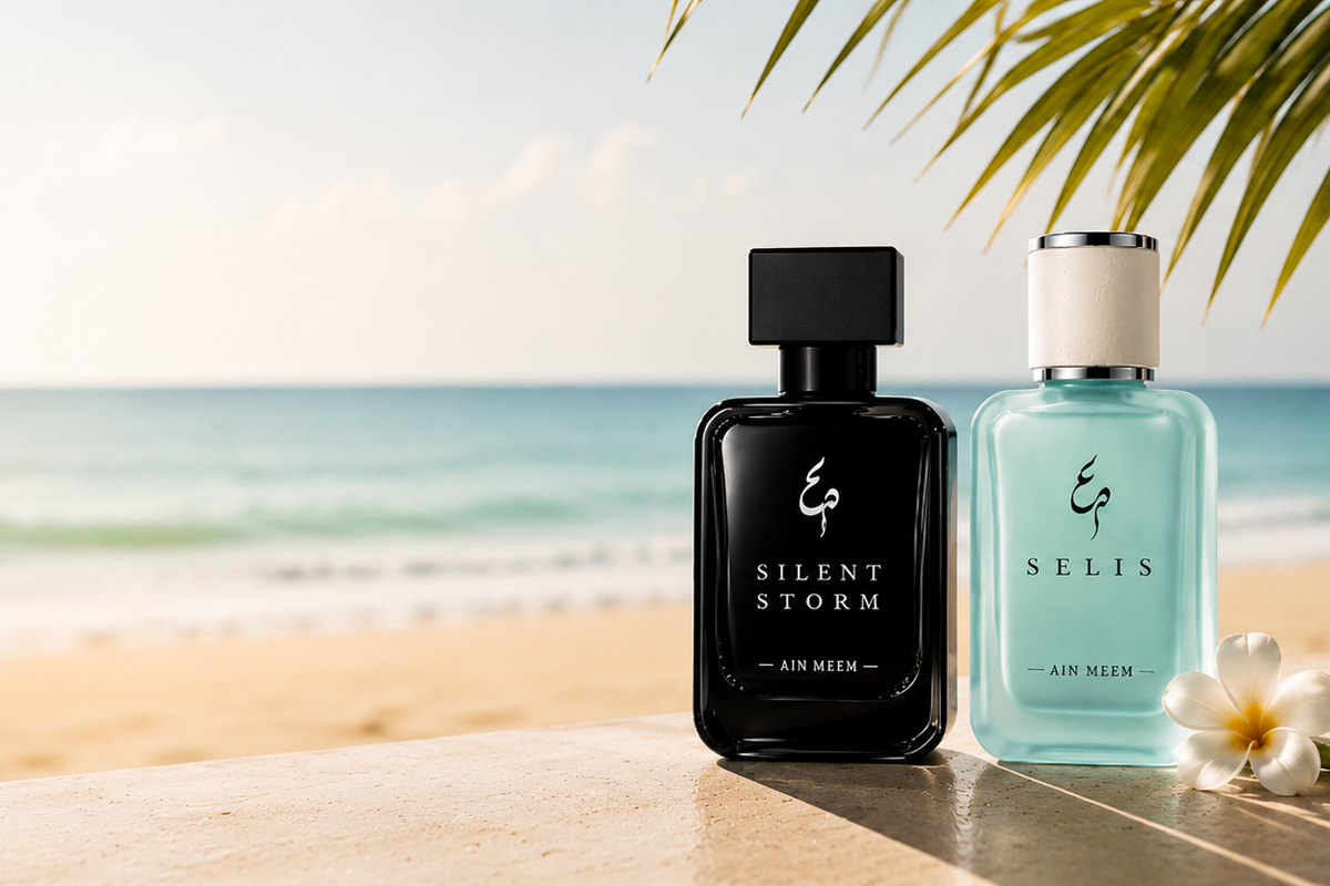 Two perfume bottles from the brand ESSENCE, labeled 'Silent Storm' and 'Belis', displayed on a beach table with a tropical ocean and palm leaves in the background.